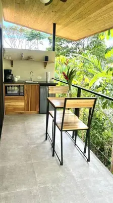 a kitchen with a table and a bench on a balcony at Sharma Costa Rica - Hawk Casita in Uvita