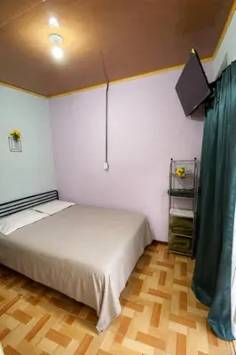 a bedroom with a bed and a wooden floor at Jungle Cabin w Pool & Nature Trails in Venecia
