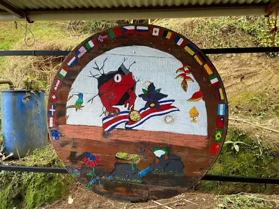 a wooden circle with a painting of a red bird at Jungle Cabin w Pool & Nature Trails in Venecia