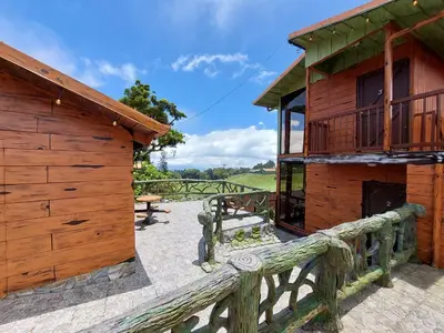 a wooden building with a bench in front of it at El Descanso Restaurante y Hotel in Fraijanes