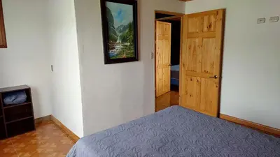 a bedroom with a bed and a picture on the wall at El Descanso Restaurante y Hotel in Fraijanes