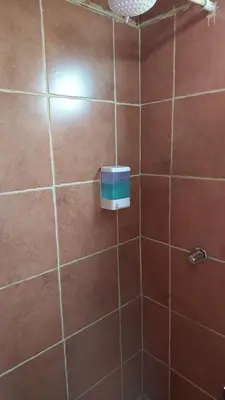 a brown tiled bathroom with a box on the wall at El Descanso Restaurante y Hotel in Fraijanes