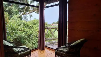 a room with two chairs and a window with a view at El Descanso Restaurante y Hotel in Fraijanes