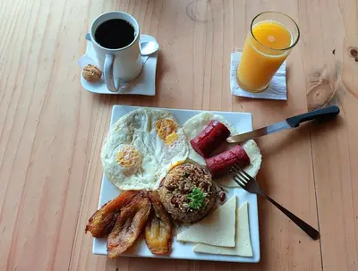 a breakfast plate with eggs and sausage and a cup of coffee at El Descanso Restaurante y Hotel in Fraijanes