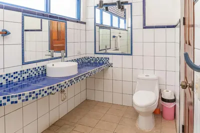a bathroom with a toilet and a sink and mirrors at Mot Mot Vacation in Sámara