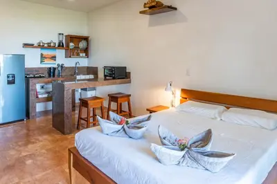 a bedroom with a large white bed with pillows on it at Mot Mot Vacation in Sámara