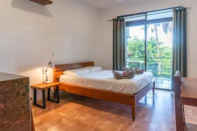 a bedroom with a bed and a large window at Mot Mot Vacation in Sámara