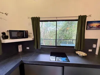 a kitchen counter with a window with a view at Pinilla Highlands Incredible mountain views in Tamarindo