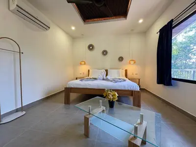 a bedroom with a bed and a glass table at Pinilla Highlands Incredible mountain views in Tamarindo
