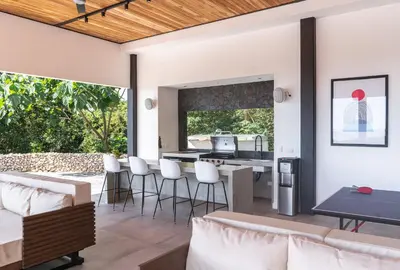 an open living room with white furniture and a kitchen at Villa Setai - Full Ocean view in Santa Teresa Beach