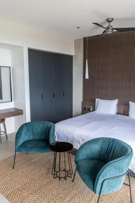 a bedroom with a bed and two chairs at Villa Setai - Full Ocean view in Santa Teresa Beach
