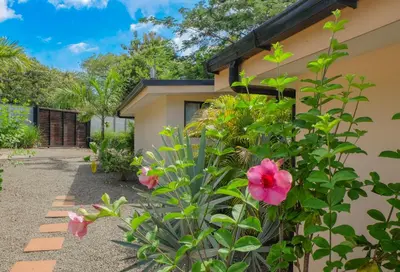 a house with pink flowers in front of it at MY - Cosy Lodges in Paraíso