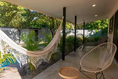 a hammock on the patio of a house at MY - Cosy Lodges in Paraíso