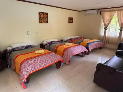 a group of four beds in a room at RIVER SIDE LODGE in Horquetas
