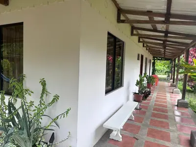a white bench sitting on the side of a building at RIVER SIDE LODGE in Horquetas