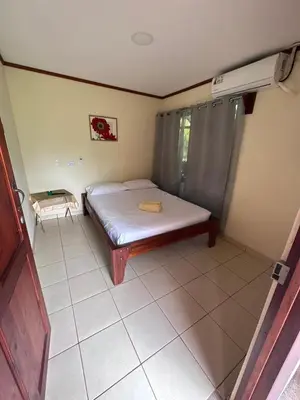 a small bedroom with a bed and a tiled floor at RIVER SIDE LODGE in Horquetas