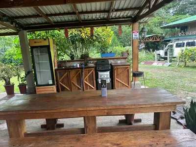 a wooden table in front of an outdoor kitchen at RIVER SIDE LODGE in Horquetas