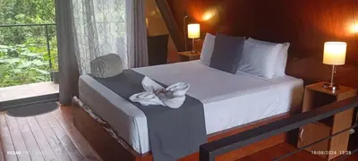 a bedroom with a bed with a flower on it at Yarumo Lodge, Río Celeste Black Chalets in Bijagua