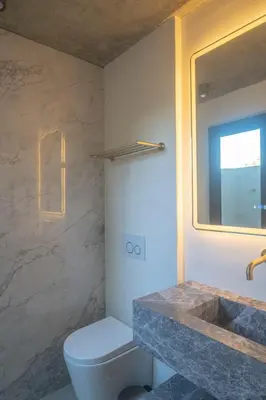 a bathroom with a toilet and a sink and a mirror at KUNUK- Walk to Hermosa beach in Santa Teresa Beach