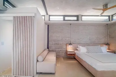 a bedroom with a large bed and a couch at KUNUK- Walk to Hermosa beach in Santa Teresa Beach