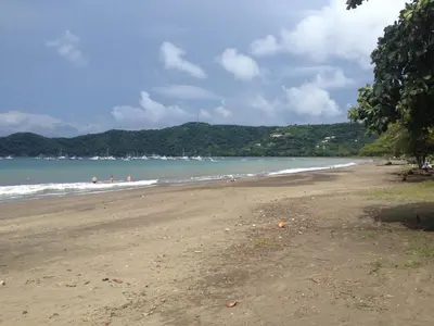 a beach with people swimming in the ocean at Hotel M&M Beach House in Coco