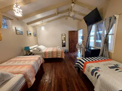 two beds in a room with wooden floors at Hotel M&M Beach House in Coco