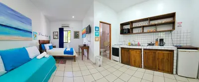 a living room with a blue couch and a kitchen at Toro Blanco in Coco