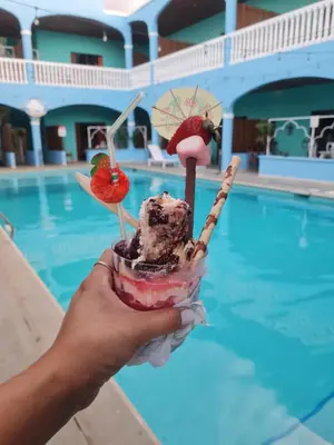 a person holding a dessert in front of a pool at Toro Blanco in Coco