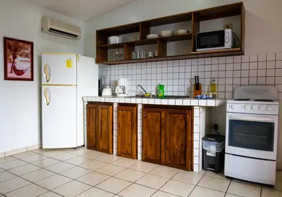 a kitchen with a white refrigerator and wooden cabinets at Toro Blanco in Coco