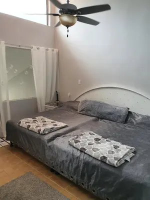 a bedroom with a bed with a ceiling fan at Very cozy beautifully designed loft apartment in Coco