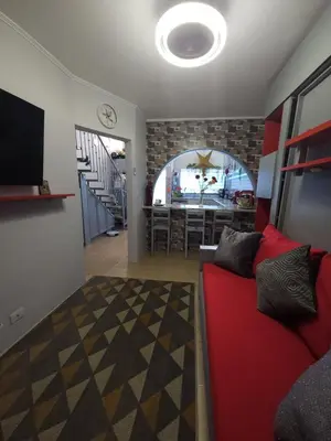 a living room with a red couch and a bar at Very cozy beautifully designed loft apartment in Coco