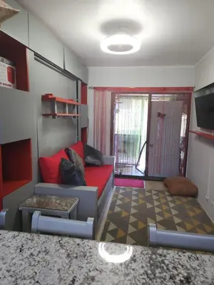 a living room with a red couch and a window at Very cozy beautifully designed loft apartment in Coco