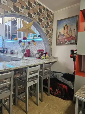 a kitchen with a counter and a table with chairs at Very cozy beautifully designed loft apartment in Coco