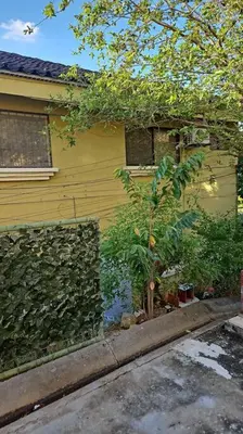 a yellow house with a garden in front of it at Very cozy beautifully designed loft apartment in Coco