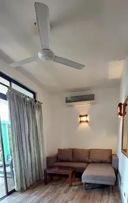 a living room with a couch and a ceiling fan at noemi apartments samara beach A-2 in Sámara