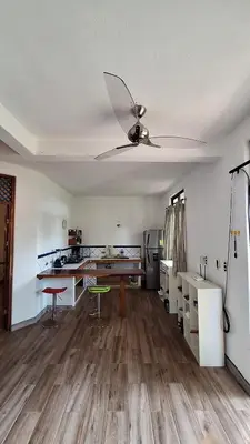 a living room with a ceiling fan and a kitchen at noemi apartments samara beach A-2 in Sámara