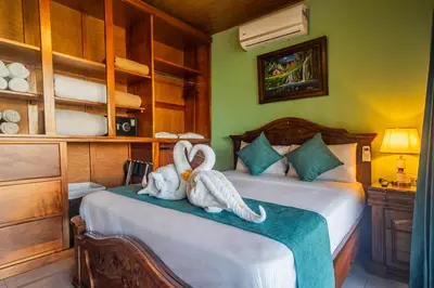 two swans sitting on a bed in a bedroom at Kaluma Villas in San Ramón