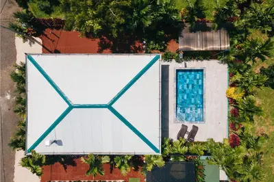 an overhead view of a white building with a swimming pool at Kaluma Villas in San Ramón