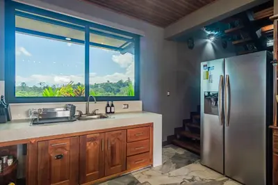 a kitchen with a sink and a large window at Kaluma Villas in San Ramón