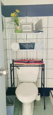 a bathroom with a toilet and a shelf with plates at Relax at Pier Sands Casita#1 - Close to the Beach! in Puntarenas