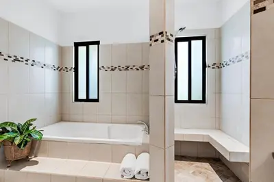 a white bathroom with a tub and a shower at Stylish Home with Chic Decor, Luxury Amenities & Tropical Outdoor Oasis with Sparkling Private Pool in Brasilito