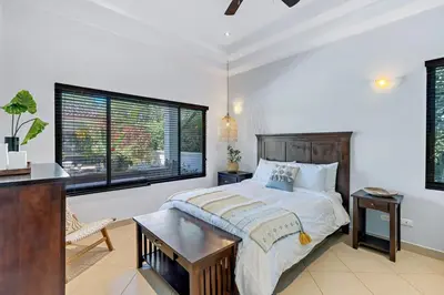 a bedroom with a large bed and a table at Stylish Home with Chic Decor, Luxury Amenities & Tropical Outdoor Oasis with Sparkling Private Pool in Brasilito