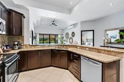 a kitchen with wooden cabinets and a counter top at Stylish Home with Chic Decor, Luxury Amenities & Tropical Outdoor Oasis with Sparkling Private Pool in Brasilito