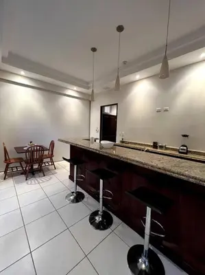 a kitchen with a bar with a table and chairs at 1 Bedroom with pool and walking distance to beach in Tamarindo