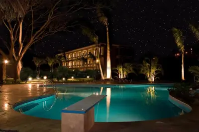 a swimming pool in front of a building at night at 1 Bedroom with pool and walking distance to beach in Tamarindo