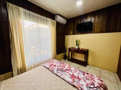 a bedroom with a bed and a tv and a window at Cabañas del Norte in Fortuna