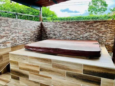 a bed sitting on a bench in front of a brick wall at Cabañas del Norte in Fortuna