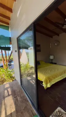 a bedroom with a bed and a sliding glass door at Eden Tica Lodge in Uvita