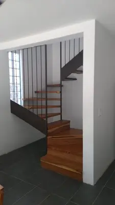 a staircase in a building with wood and metal railing at Green Turtle Townhome #1 Private Pool & Garden 300 Mtrs to Beach in Tamarindo