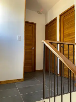 a hallway with two wooden doors and a staircase at Green Turtle Townhome #1 Private Pool & Garden 300 Mtrs to Beach in Tamarindo